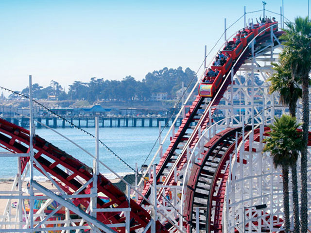 Red Giant Dipper with passenger waving their arms up as they go down the ride. 