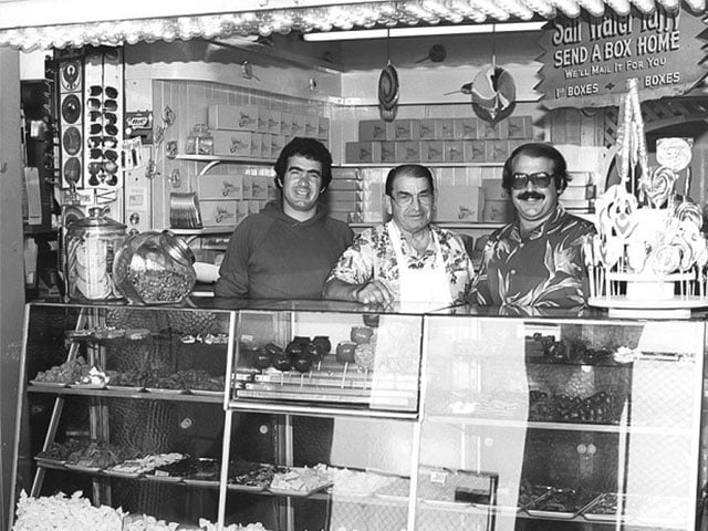 SC Boardwalk black and white image of Marini Candy store front, three men