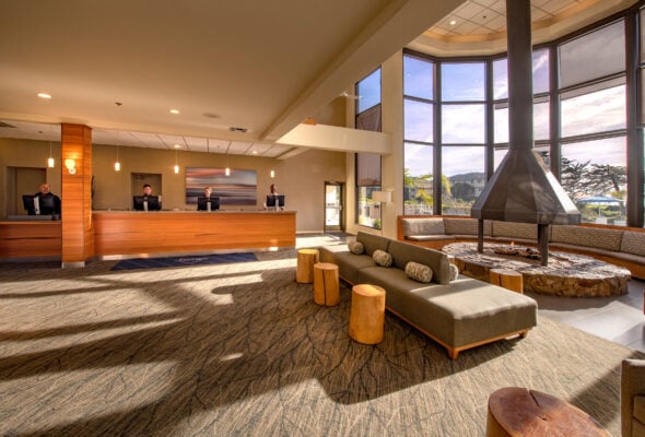 Seascape Resort lobby with fireplace and large windows that light shines in from. 