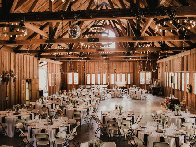 Event inside Barte Hall at Roaring camp. High wooden beams have string lights and disco balls. 