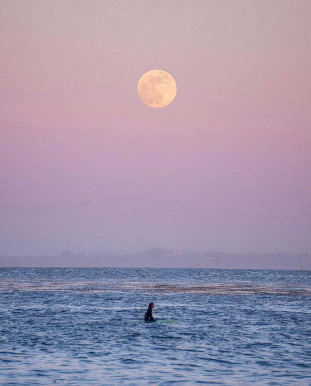 Best of 2021: This Photo is one of the top posts for 2021 on the Visit Santa Cruz County Social Media Channels. This photo of a full moon with a surfer on the ocean. Photo by SomewhereSierra..