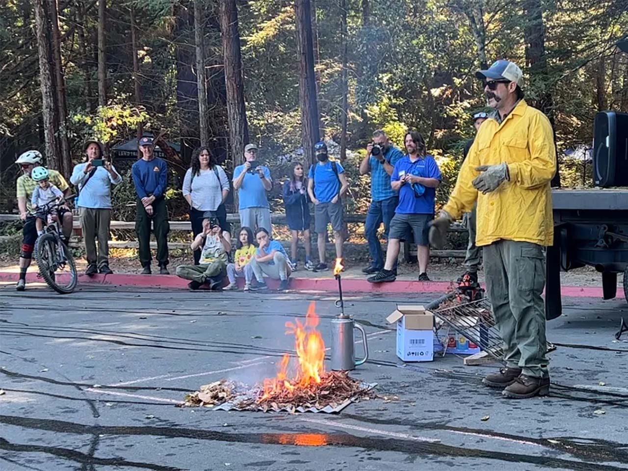 Fireman demonstrating a safe fire to families while speaking