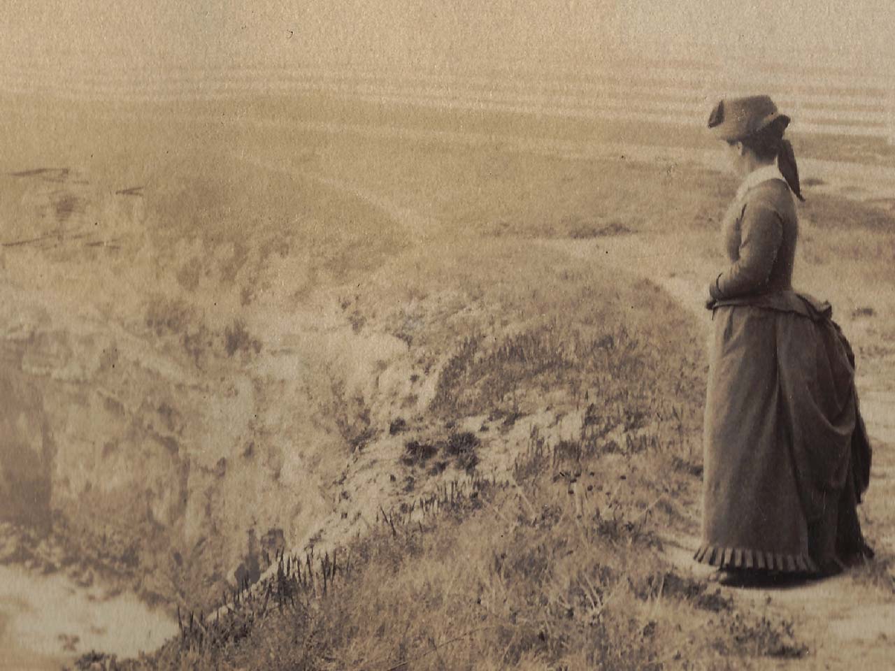 Old Victorian picture of Laura overlooking a cliff and the ocean.