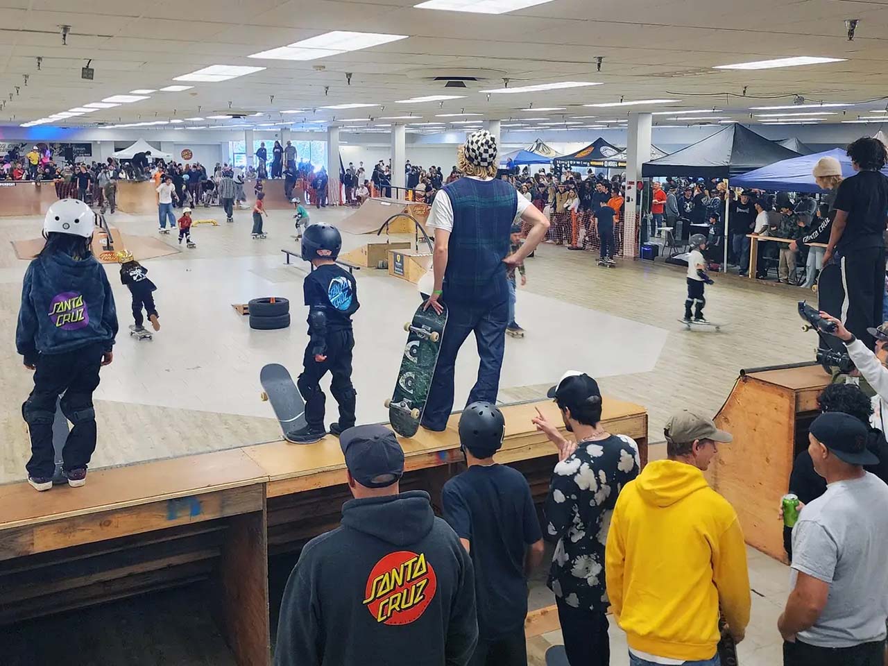 Kids skating on ramps and spectators enjoying food and live music