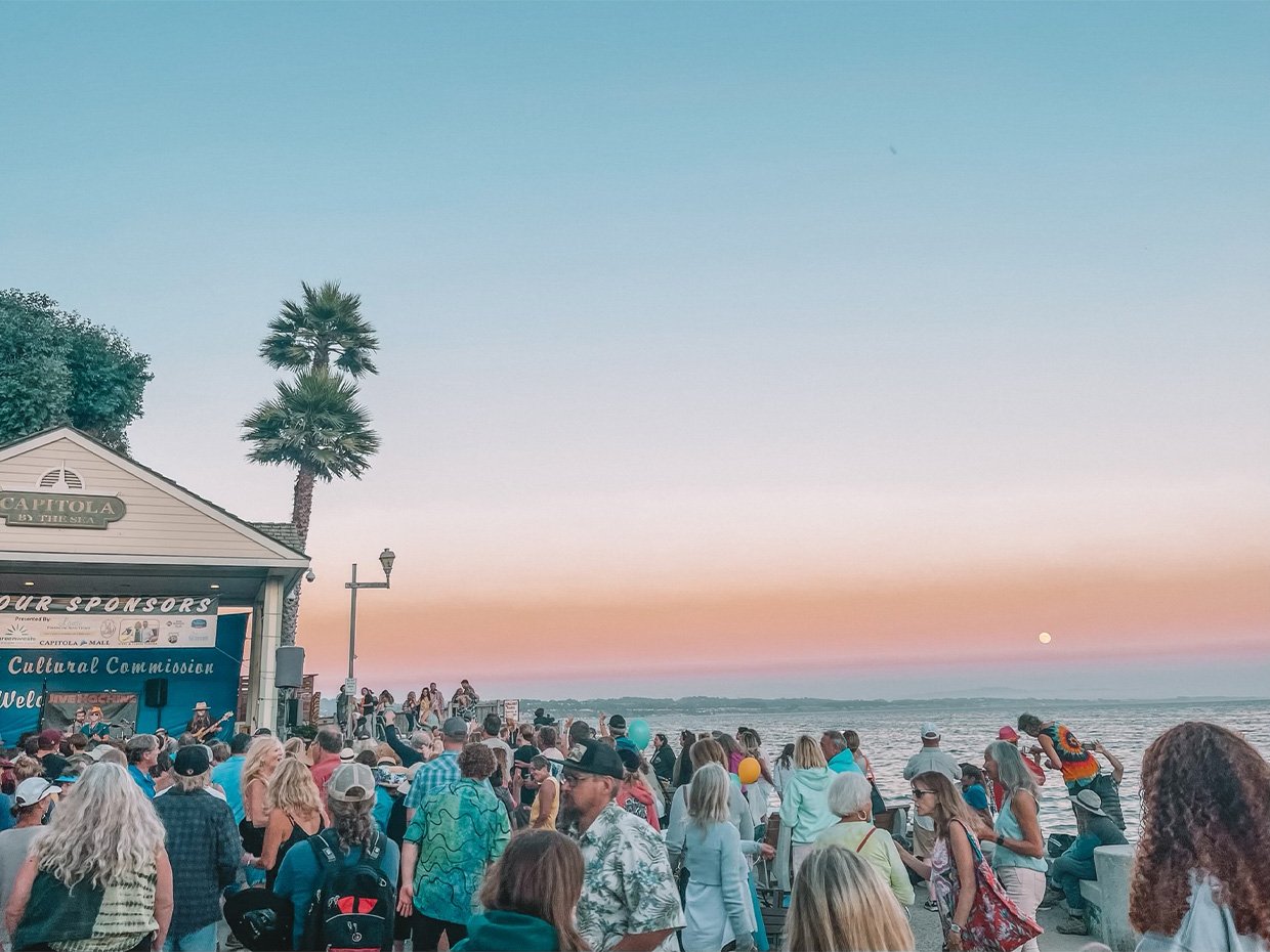 Group of individuals enjoying a live band at Capitola Twilight Concert at twilight. Photographed by Rachel Endsley, edited by Jenn Day