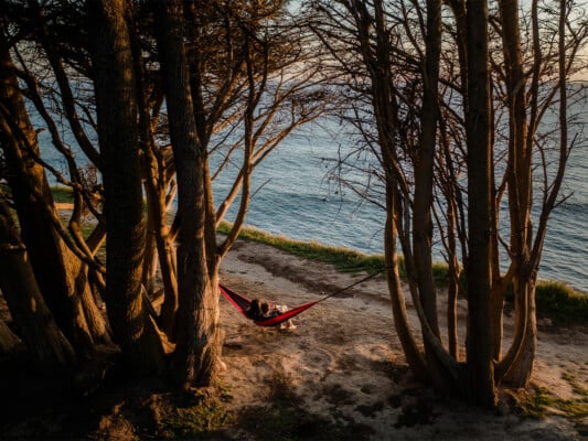 Couple sitting on a hammock between two trees at Davenport. Photographed by Ben Ingram