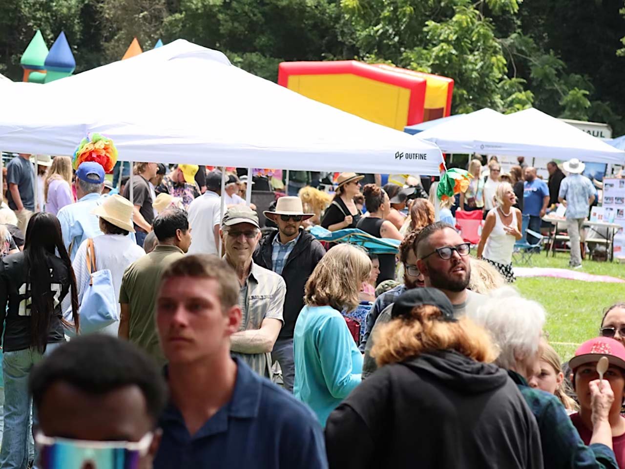 A crowded festival with tents and activities