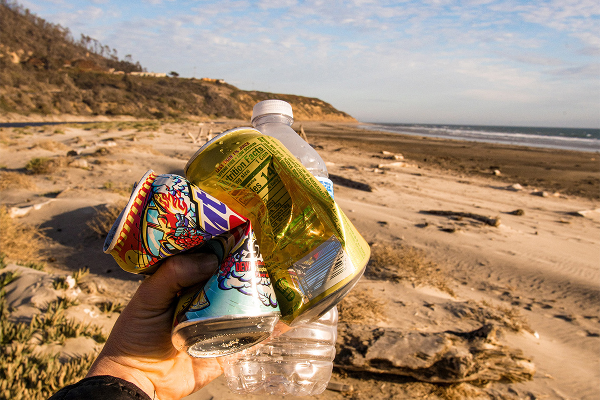 "Pack your trash". Empty cans and an empty water bottle picked up from the beach. Photographed by Liz Birnbaum, the Curated Feast