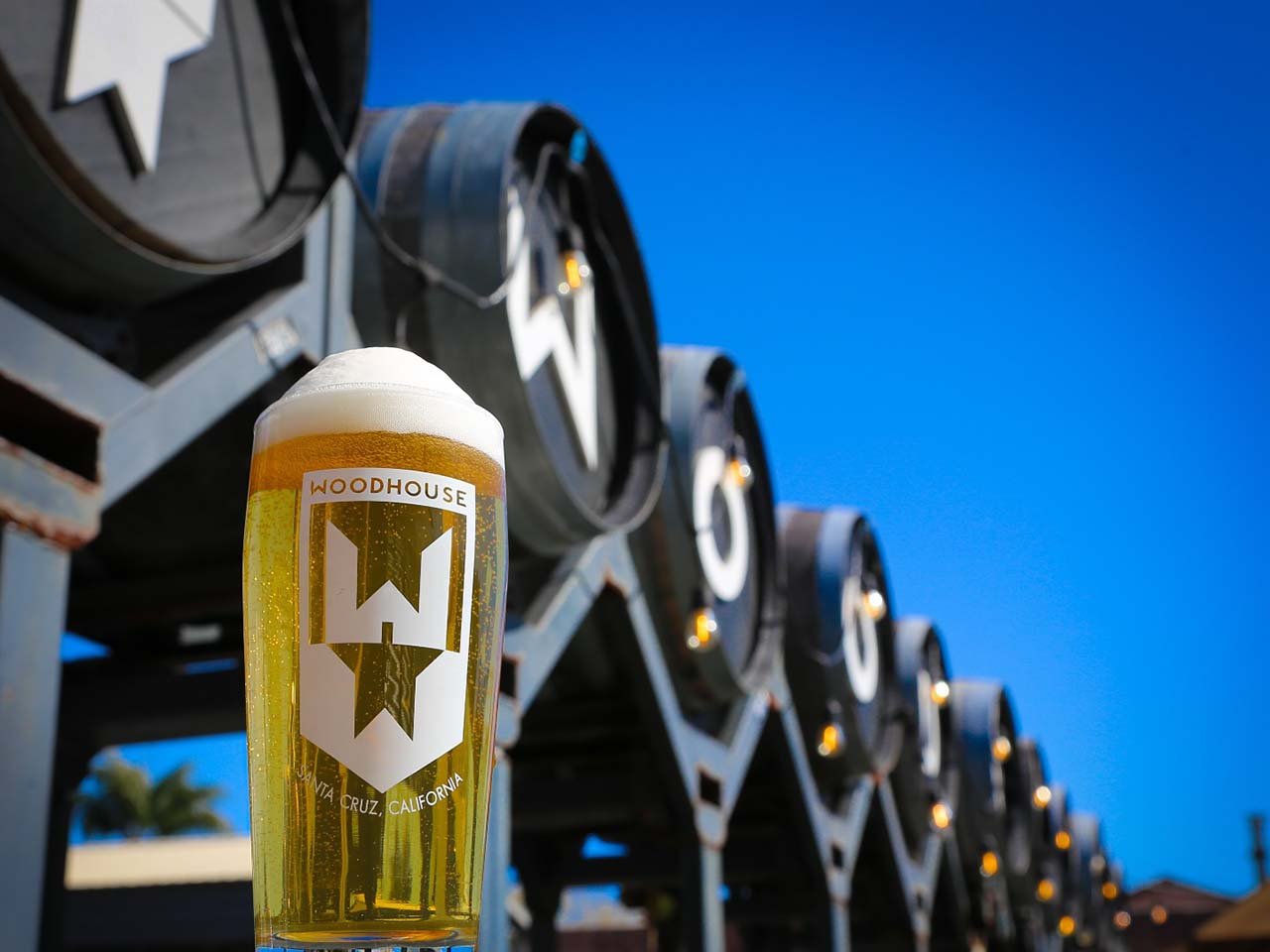 Glass of beer in front of beer bottle spelling out Woodhouse