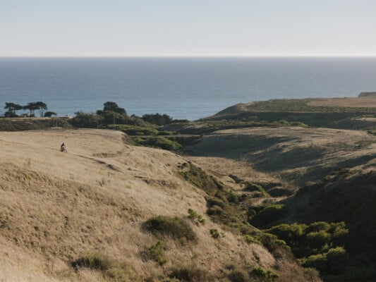 Mountain biker with a view of the ocean at Cotoni Coast Dairies. Photographed by Ben Ingram