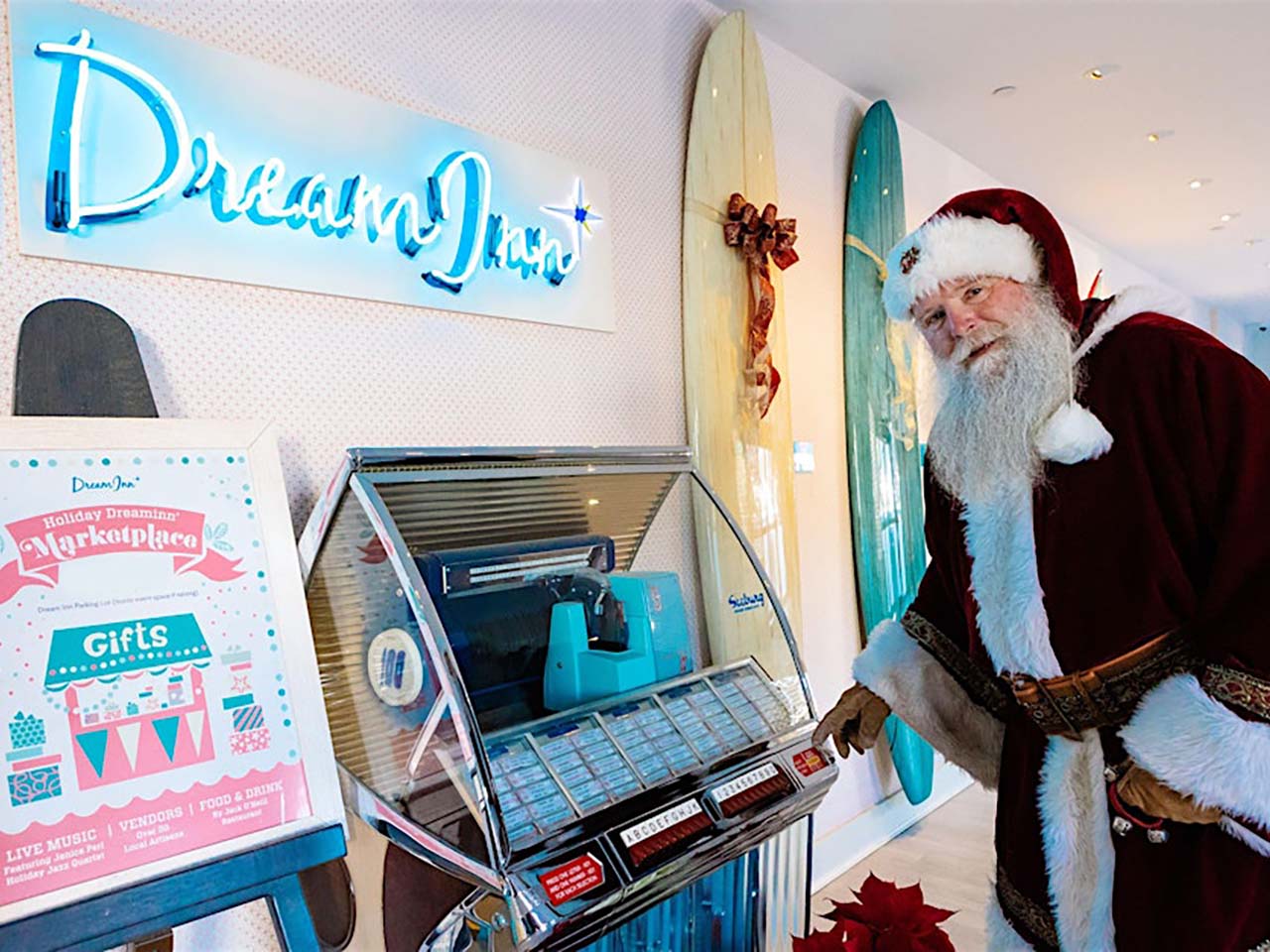 Santa selecting a song from the jukebox at under the Dream Inn neon sign.