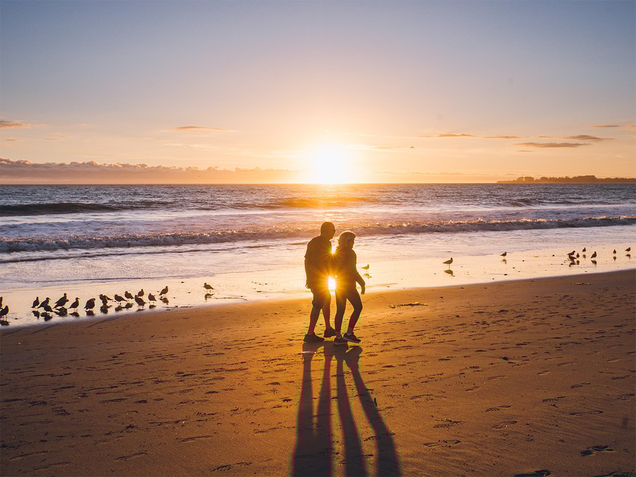 Two individuals walking at Rio Del Mar Beach during sunset. Photographed by Liz Birnbaum, The Curated Feast