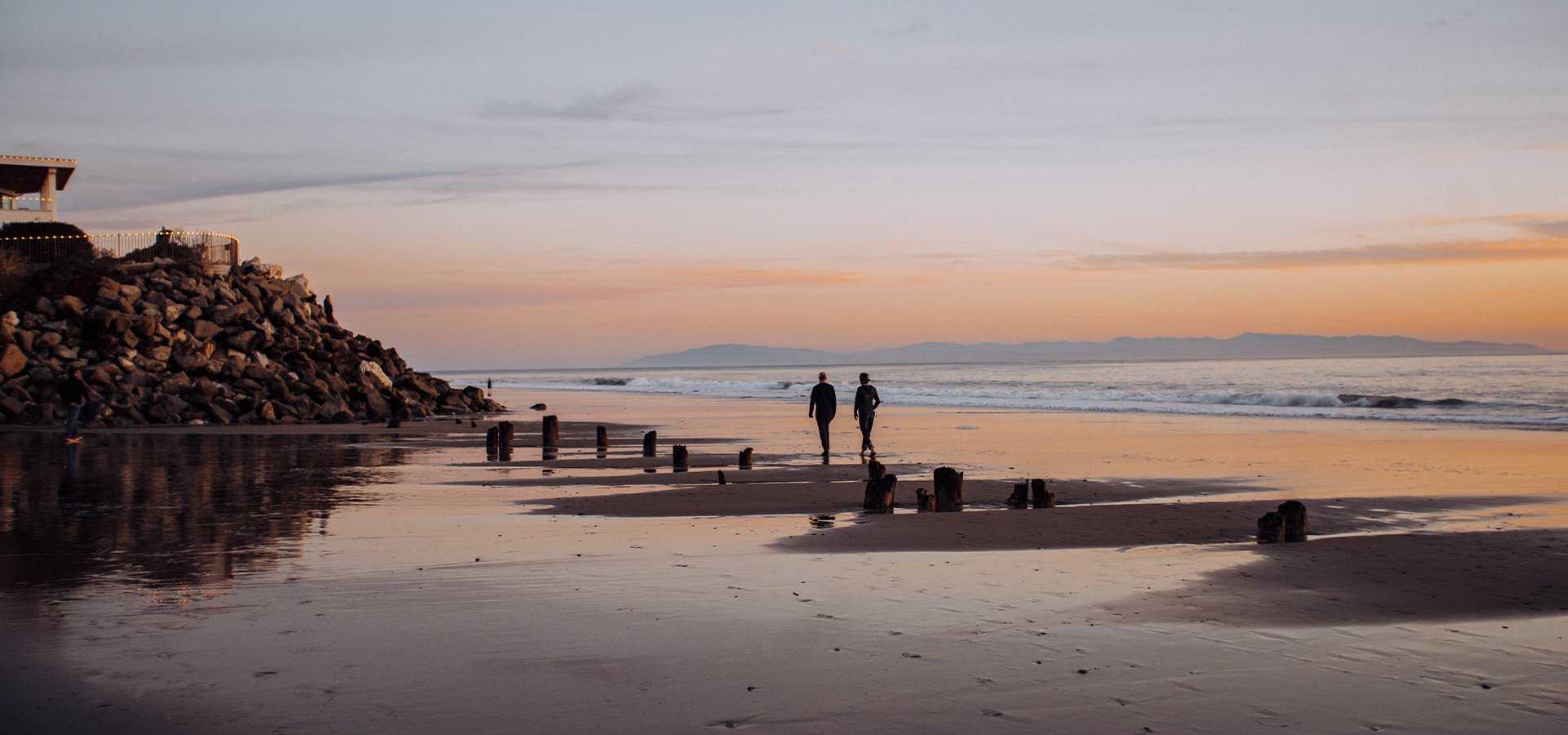 Two individuals strolling along Twin Lakes State Beach. Photographed by Liz Birnbaum, The Curated Feast