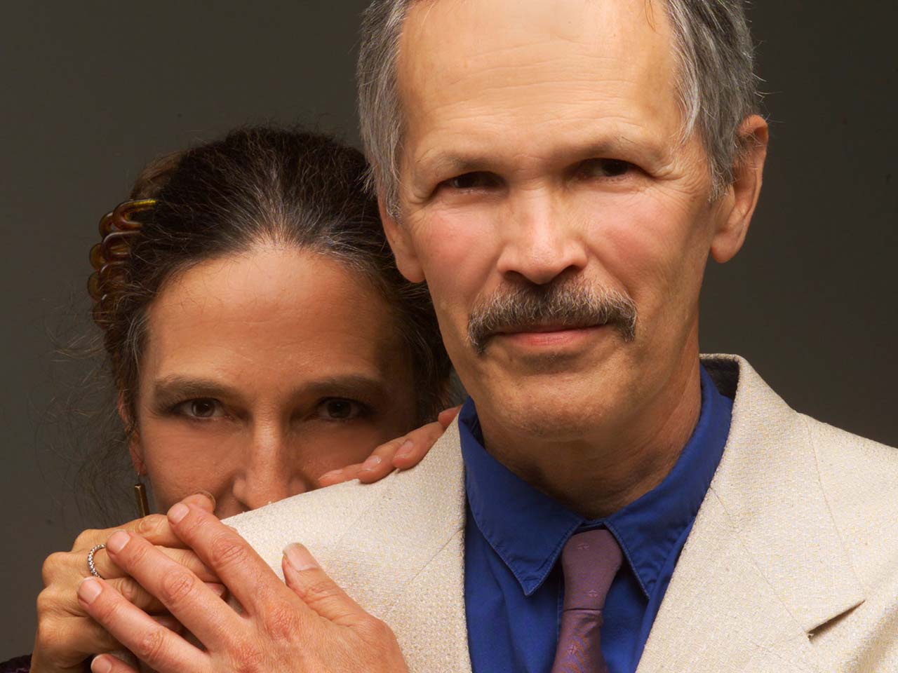 Jon Scoville holding the hand of his wife peeking over his shoulder