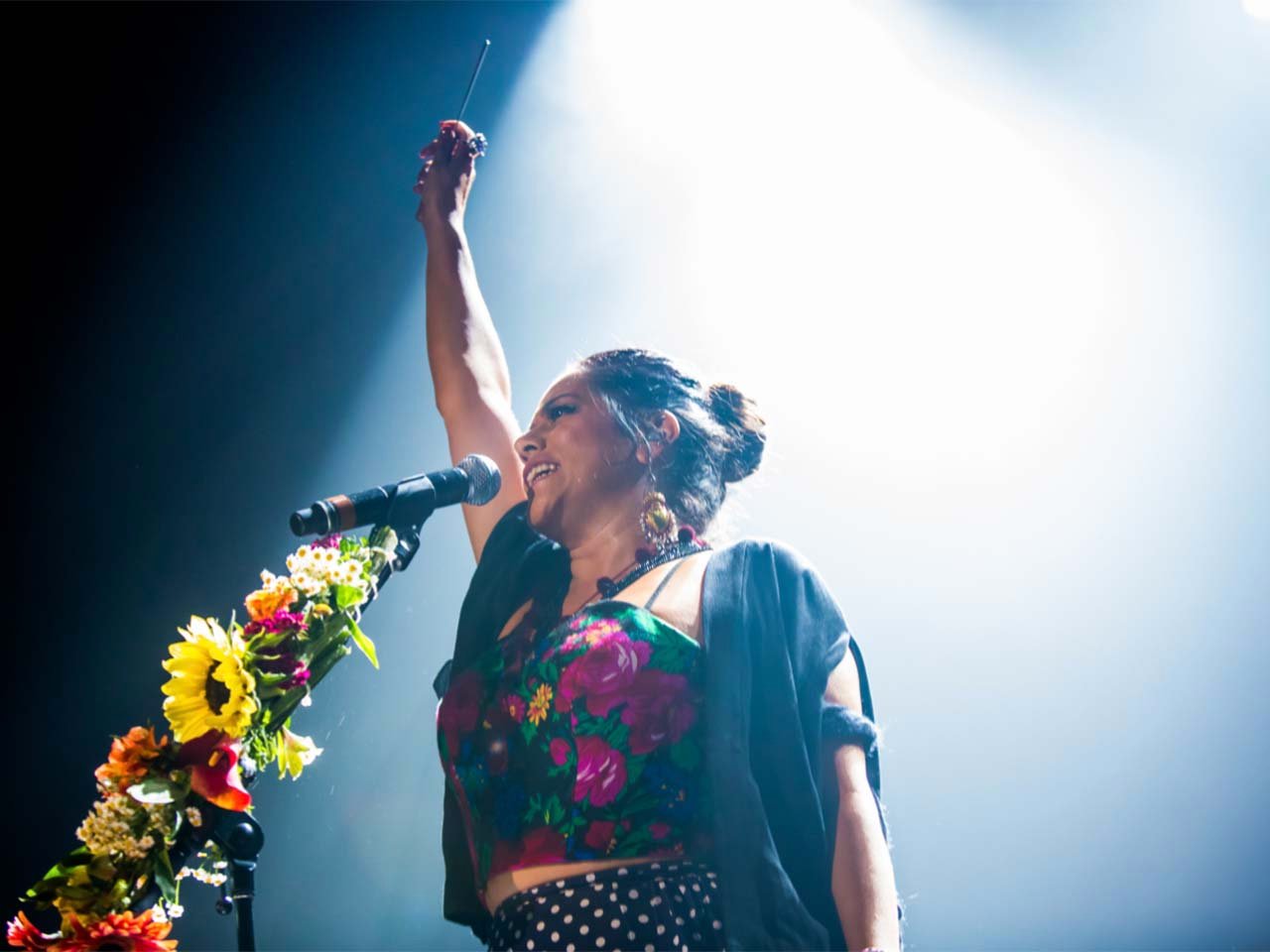 performer wearing traditional clothing with arm in the air