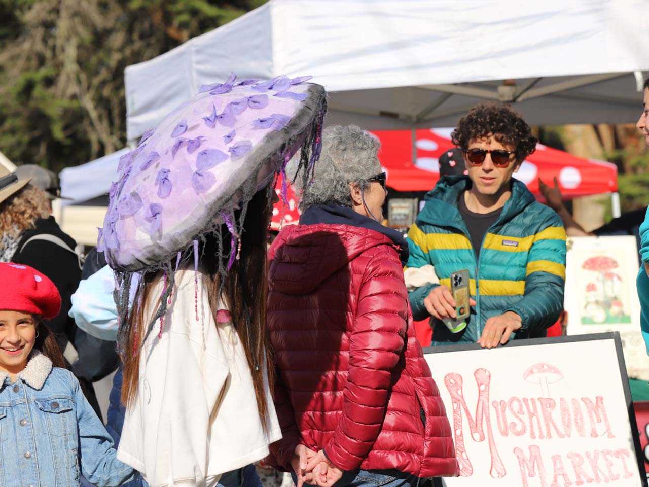 Outdoor festival with people wearing wacky mushroom hats