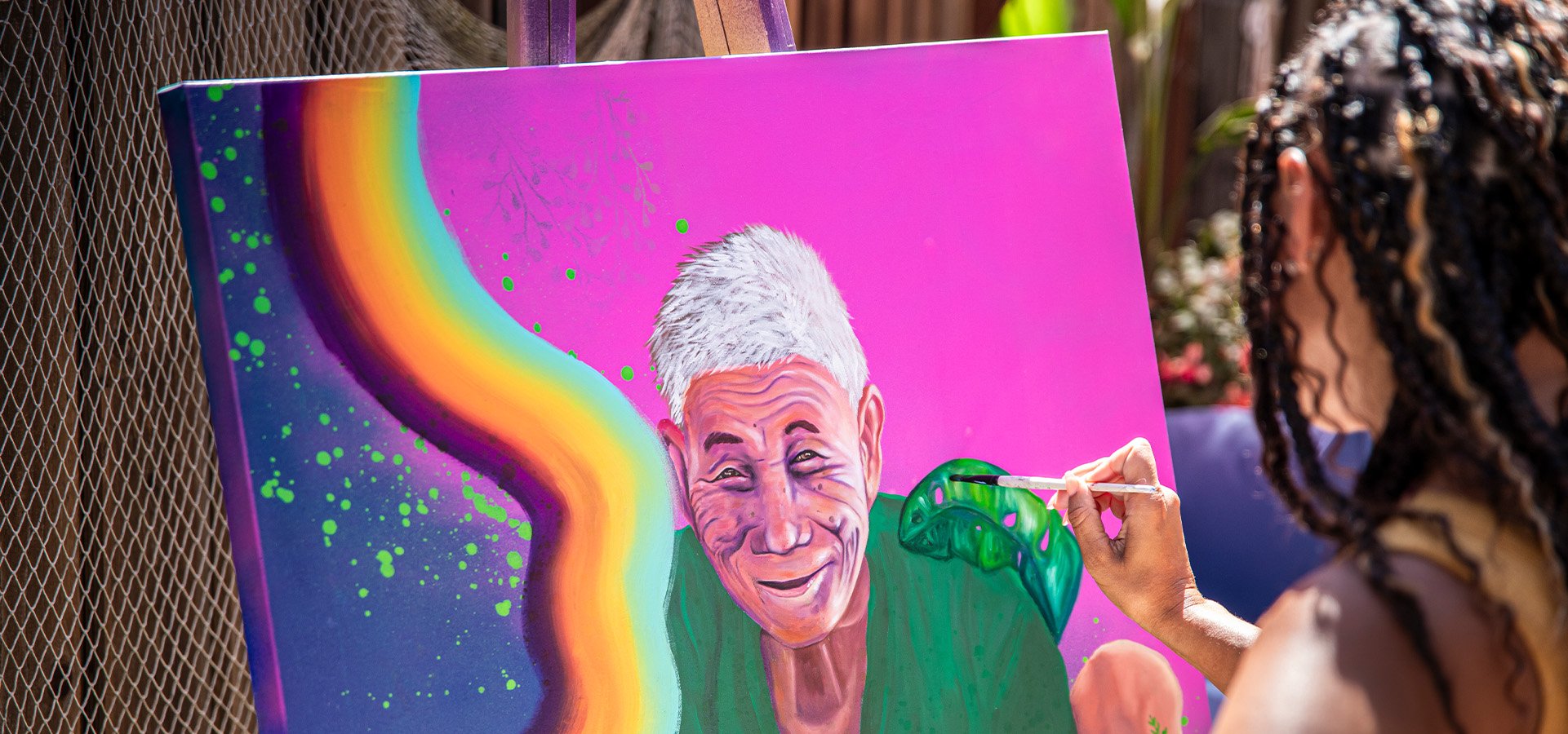 Artist Abi Mustapha painting an older woman. Photographed by Impact Creative