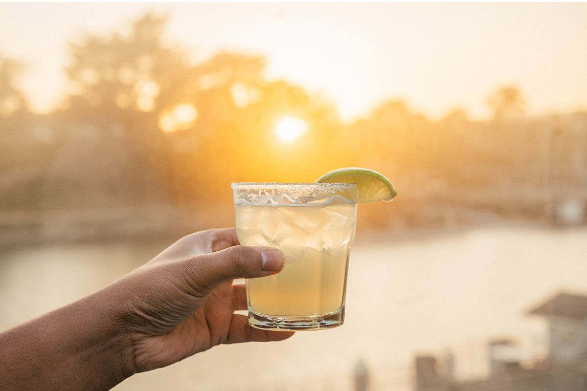 A cocktail held up to the flow of the sunset. Photographed by Liz Birnbaum, The Curated Feast