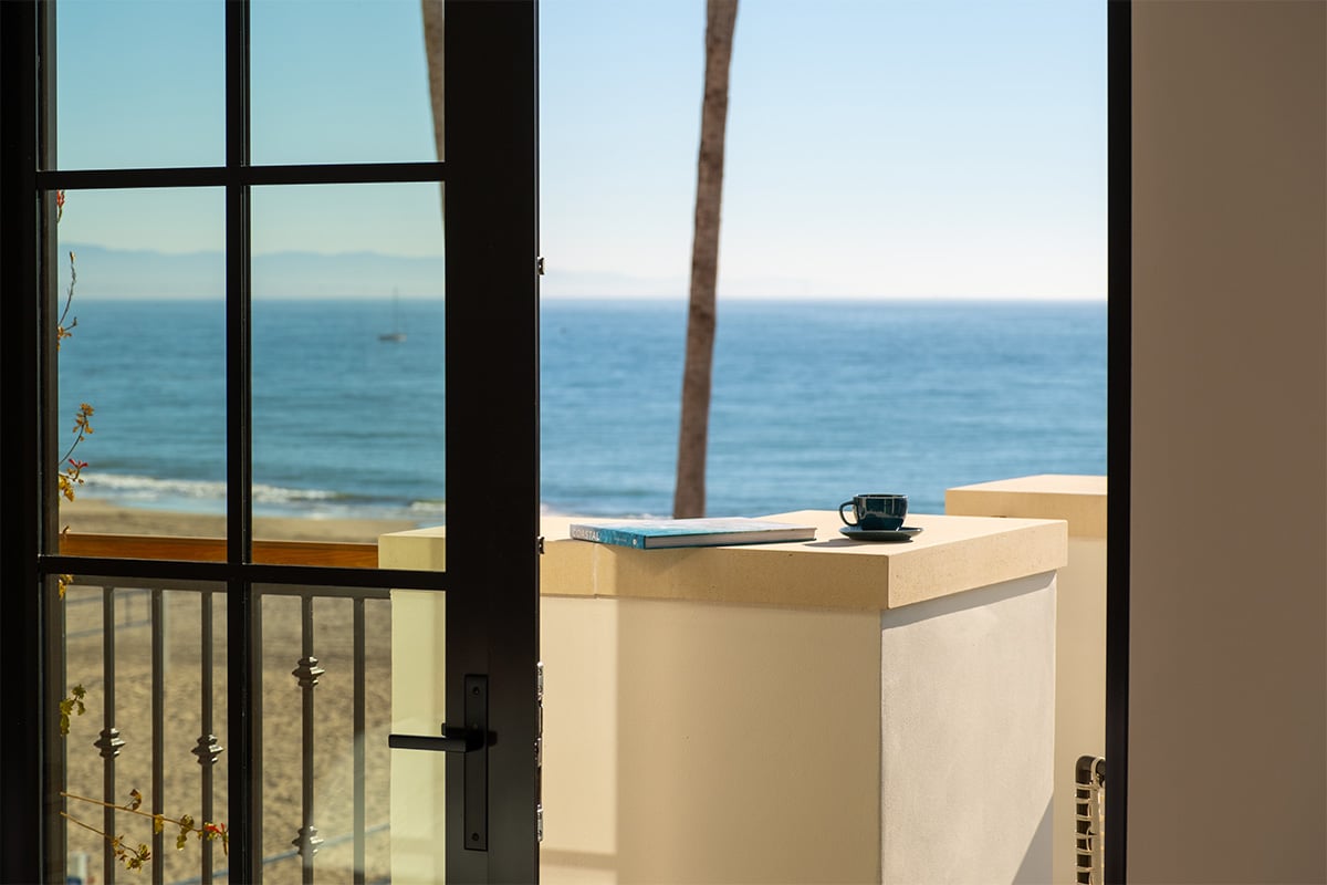 Coffee/Tea cup next to a book on the balcony of La Bahia Hotel & Spa with a view of the Monterey Bay. Photographed by Daniel Gorosieta