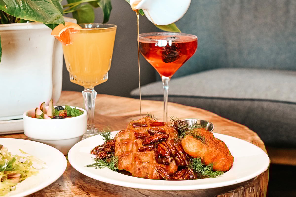 Plates of entrees with cocktails at The Grille at DeLaveaga. Photographed by Jenn Day