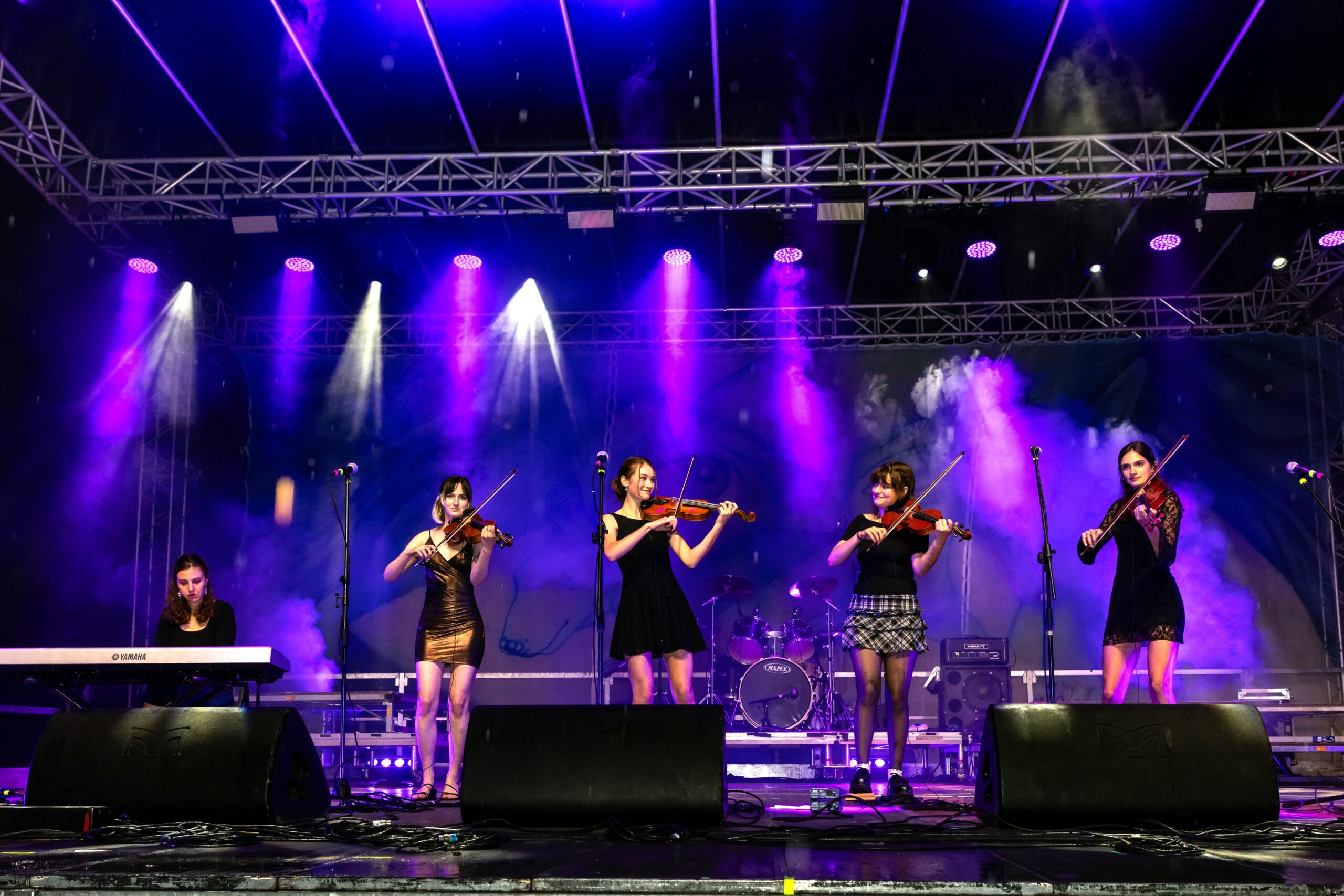 women with fiddles on a stage