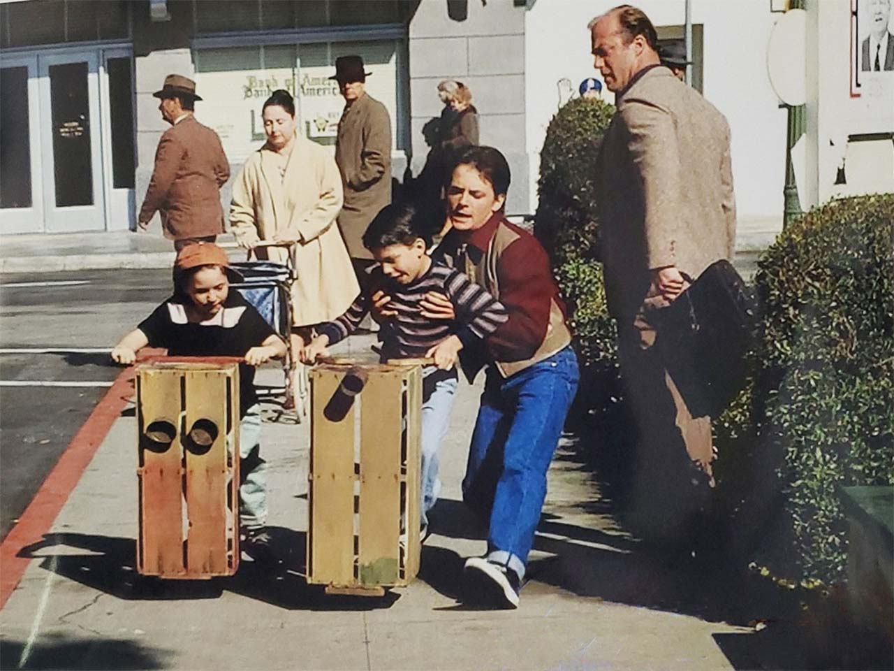 Marty McFly taking a kid off an orange crate scooter for the famous skateboarding scene