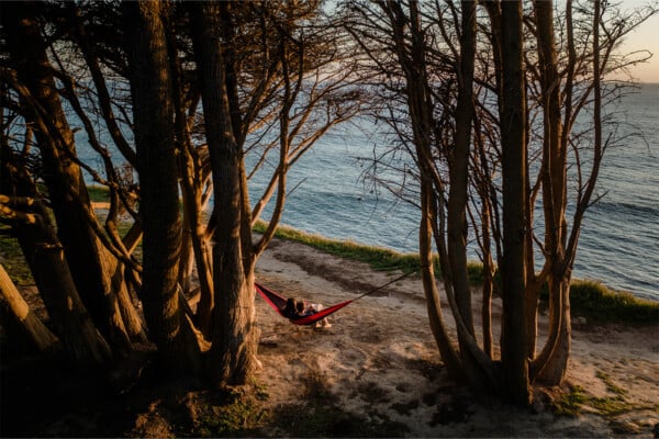Two people sitting on the hammock in Davenport overlooking the ocean. Photographed by Ben Ingram