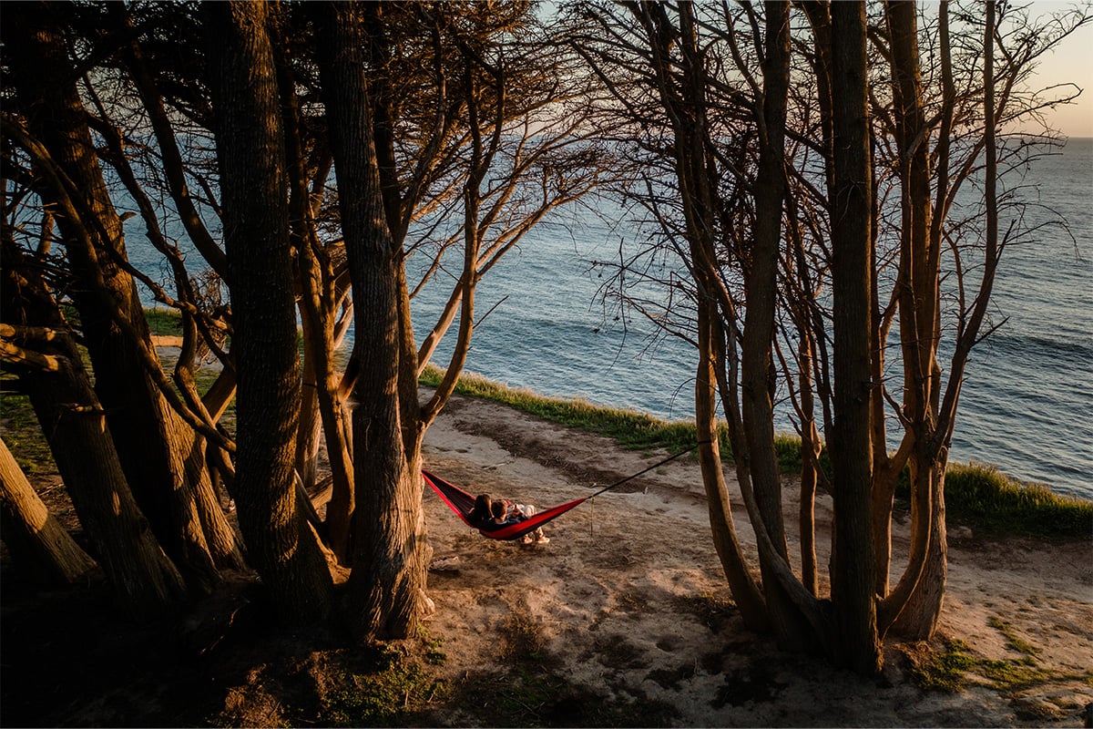 Two people sitting on the hammock in Davenport overlooking the ocean. Photographed by Ben Ingram