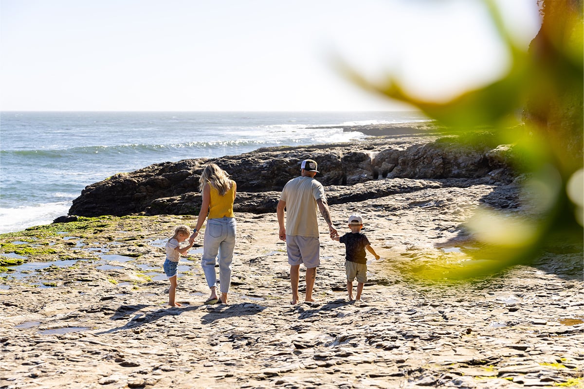 Two Parents with their two children are walking the beaches of Natural Bridges during a sunny day. Photographed by Daniel Gorostieta