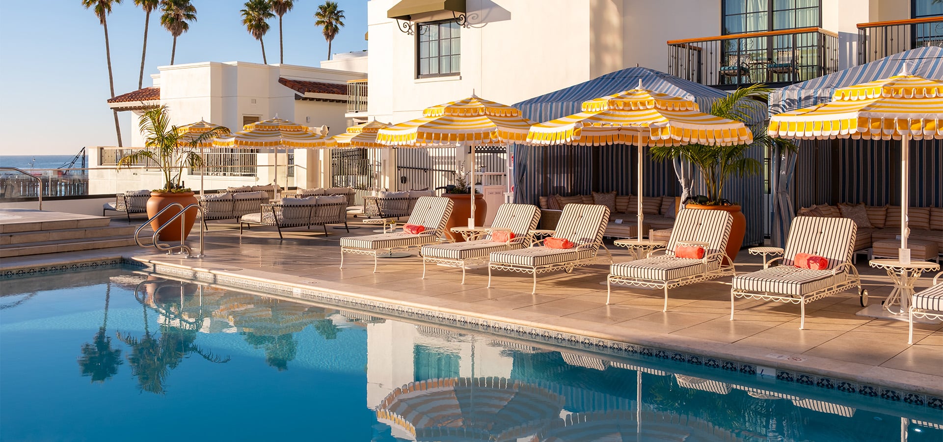 Lounge chairs and umbrella lined up along the pool with the ocean view at La Bahia Hotel & Spa. Photographed by Daniel Gorostieta