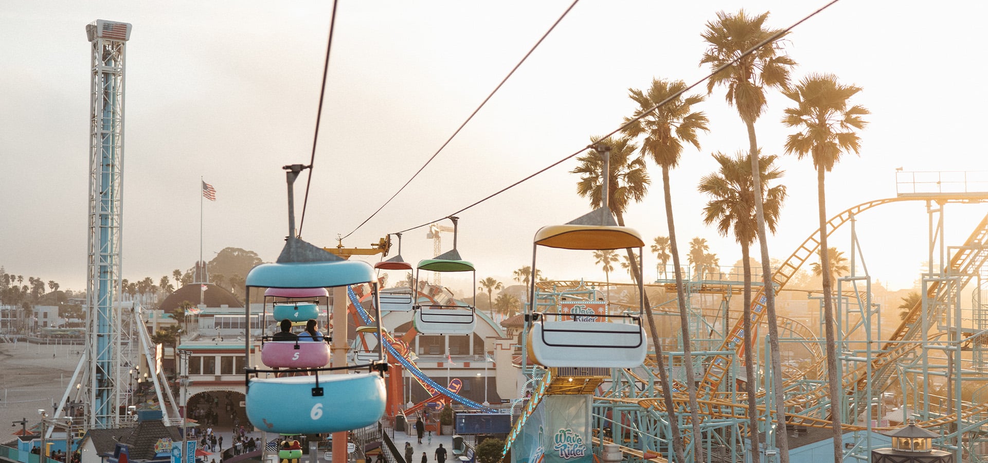 Two people on the Skyglider ride at the Santa Cruz Beach Boardwalk during sunset. Photographed by Ben Ingram