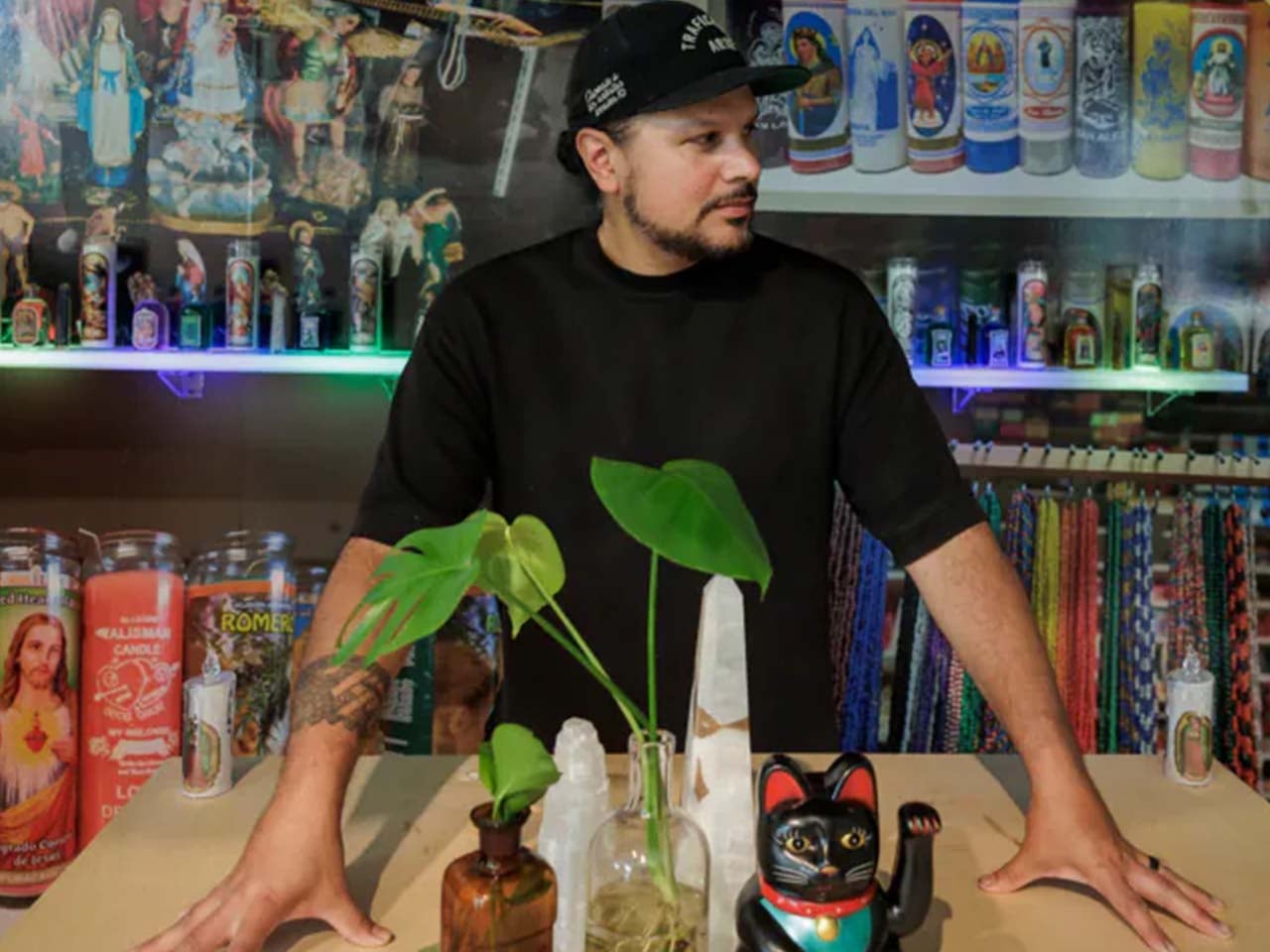 Artist standing behind a plant and some objects